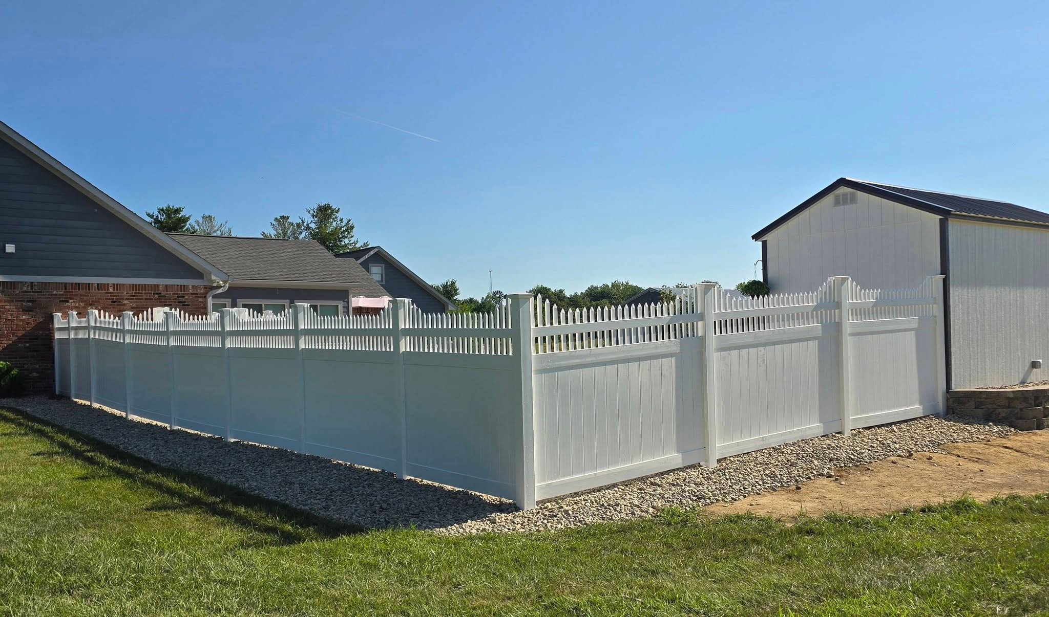 White Summit vinyl fence between a home and outbuilding