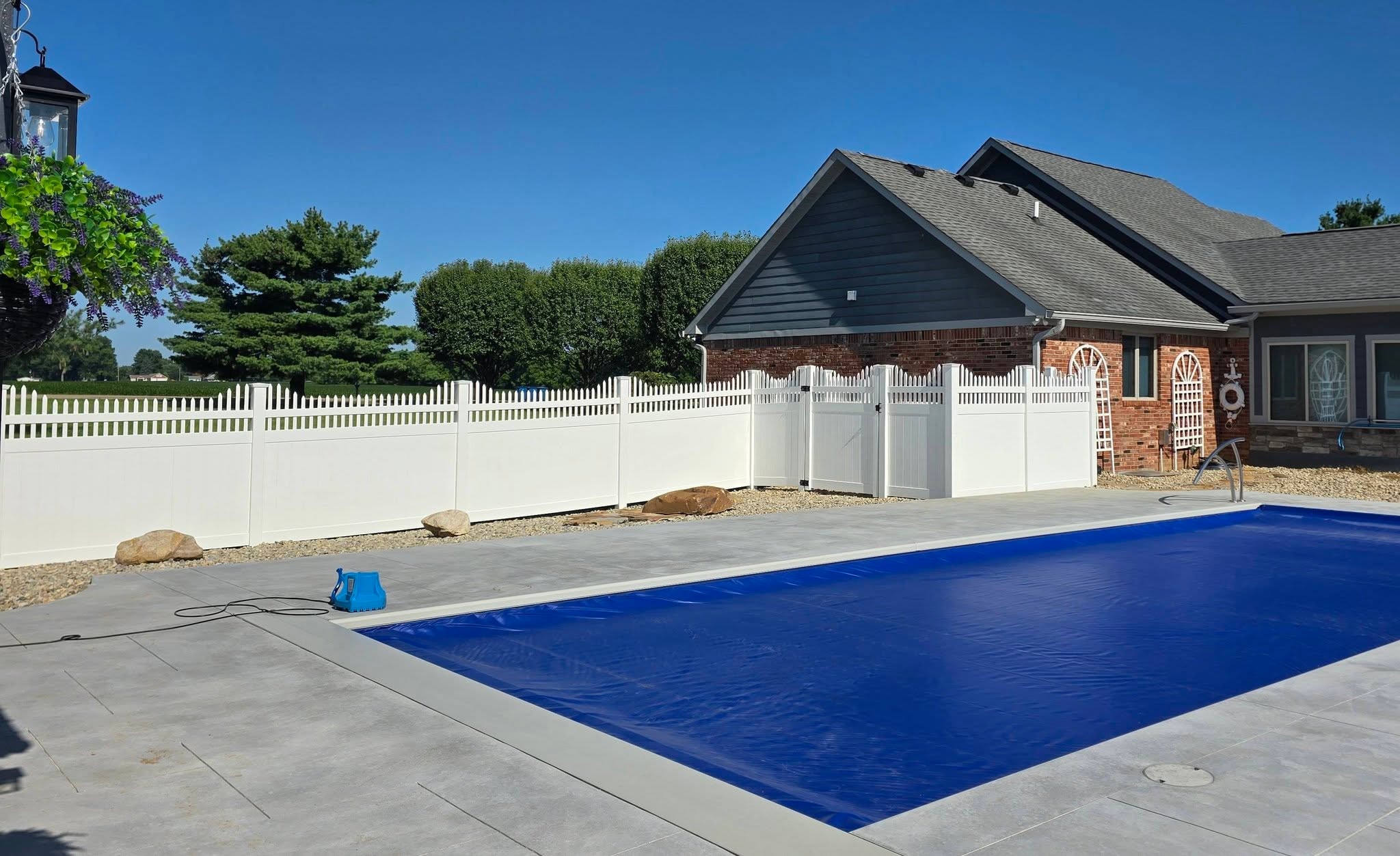 White Summit vinyl fence with gate surrounding a backyard pool